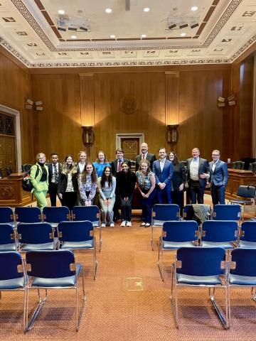 Group of students posing in a committee room 