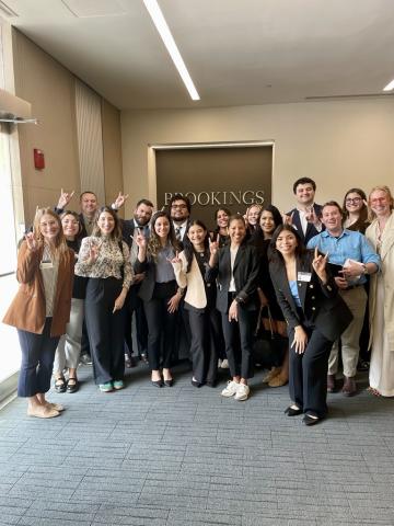 Students standing in front of the Brookings Institute sign.
