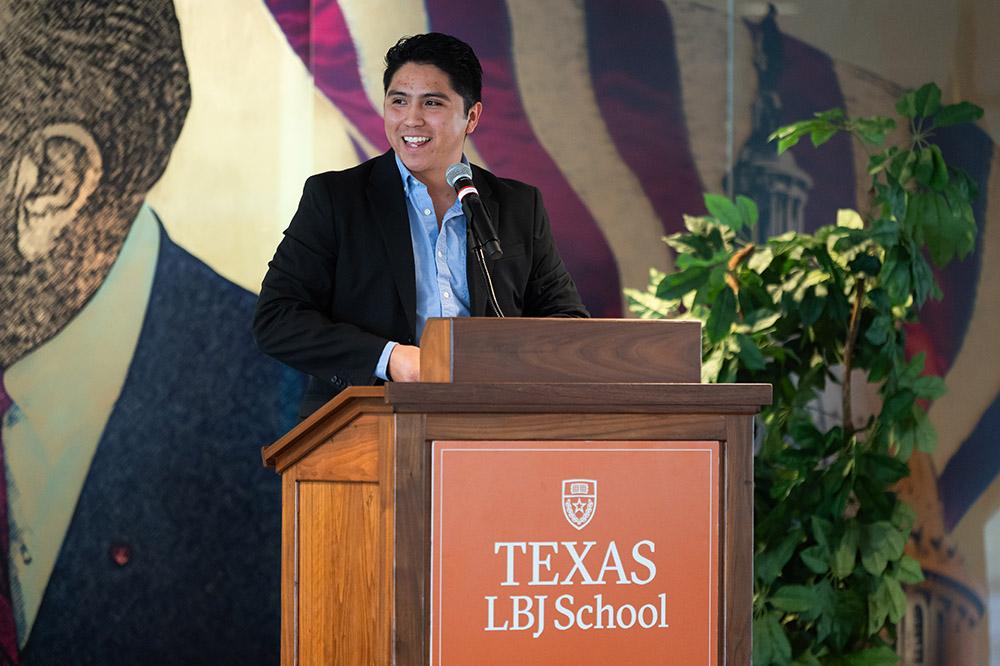 young man stands behind a podium