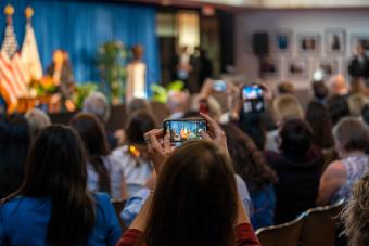 audience member taking photo of speaker with phone